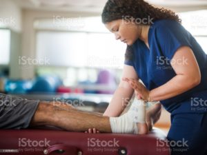A man getting his ankle wrapped since he sprained it.