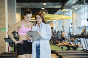 Sports medicine physician talking to a young female patient