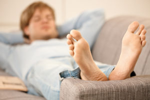 Man laying on the couch with his feet up