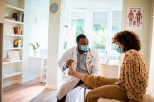 Doctor examining a female patient's foot