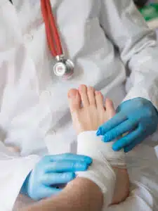 Close up of doctor bandaging one injured foot