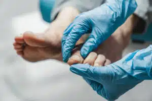 Podiatrist treating feet during procedure & giving foor care tips to patient