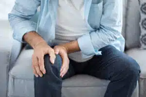 Old man suffering from knee pain caused by Osteoarthritis in the ankle and foot.